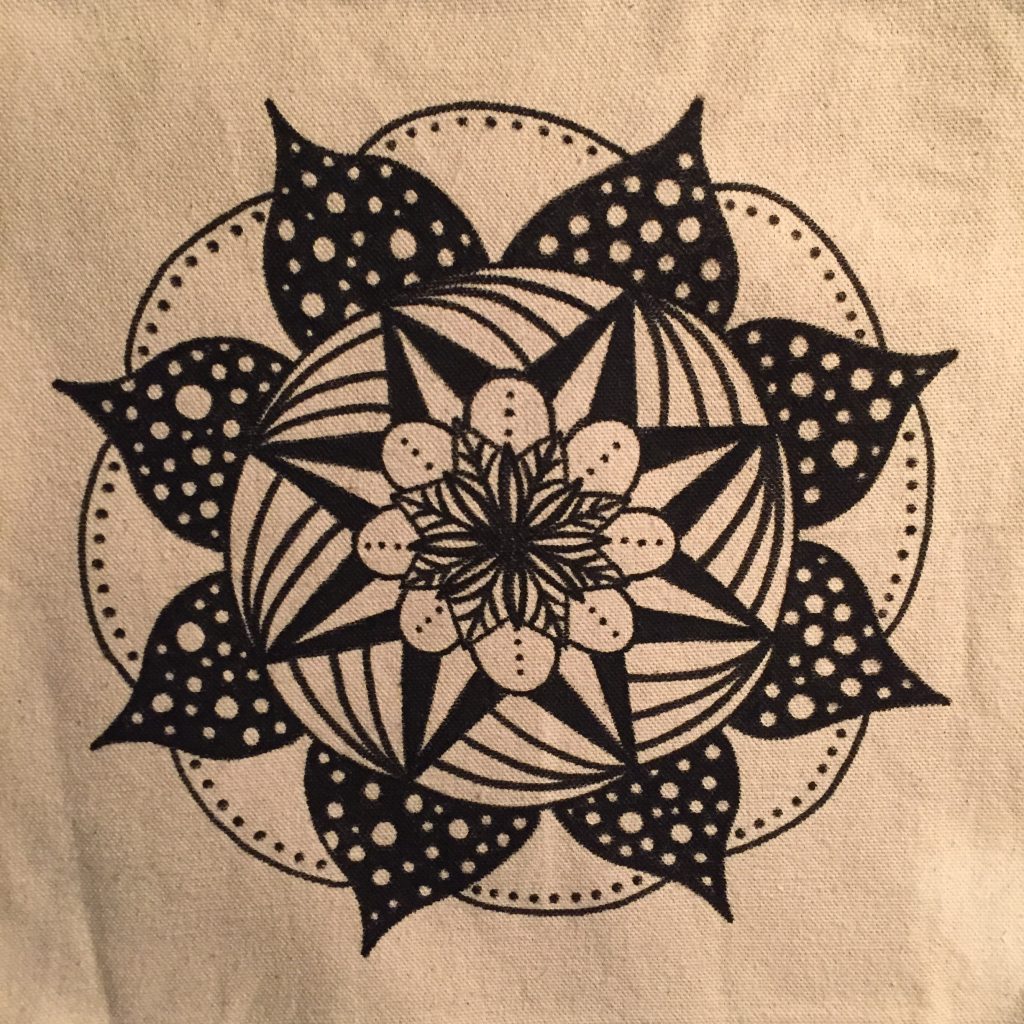 hand drawn black and white polka dot mandala on a cream colored tote bag