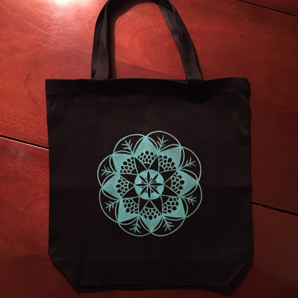 hand drawn teal mandala on black canvas tote bag
