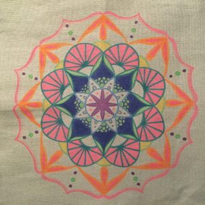 hand drawn tropical mandala in pink, blue green and orange on a grey tote bag