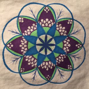 Hand drawn budding flower mandala in green, blue and purple on a white tote bag