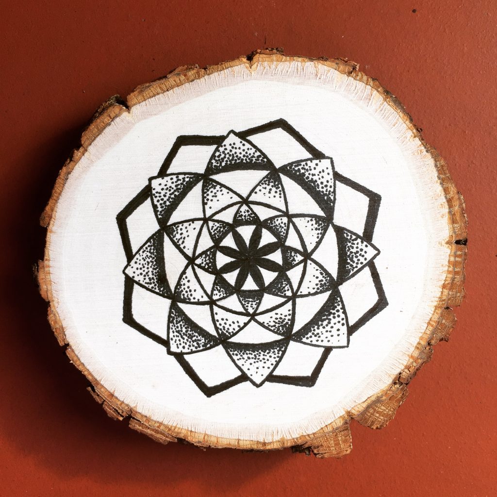 black ink star mandala on wood